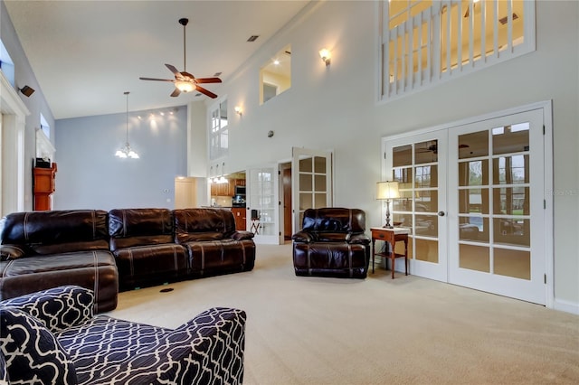 living room with carpet floors, french doors, and ceiling fan with notable chandelier