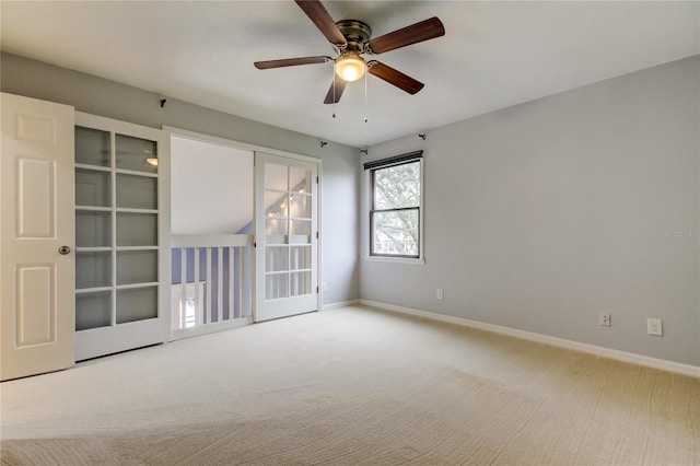 carpeted empty room featuring a ceiling fan and baseboards