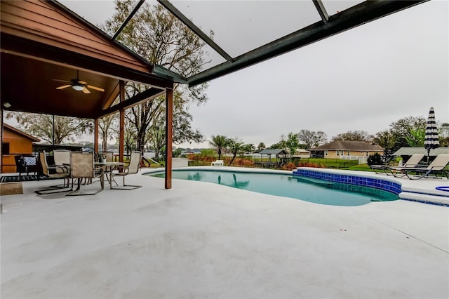 pool featuring ceiling fan, a patio, fence, and glass enclosure