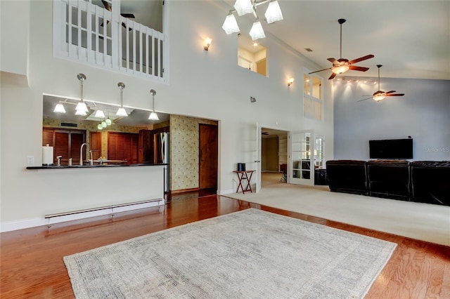 living room featuring a baseboard radiator, wood finished floors, and baseboards