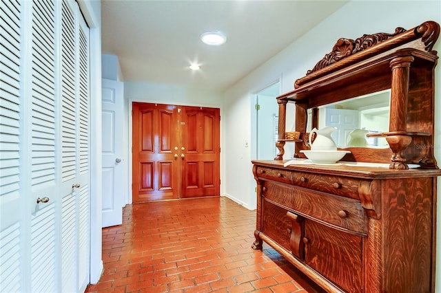 hall with brick floor and baseboards