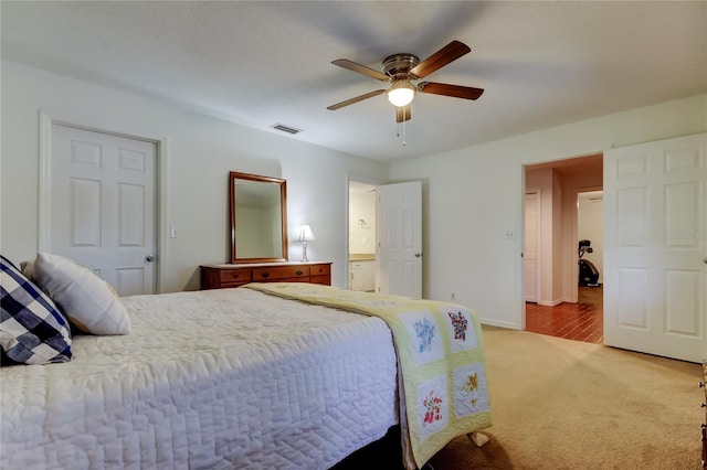 bedroom with ceiling fan, connected bathroom, light carpet, visible vents, and baseboards