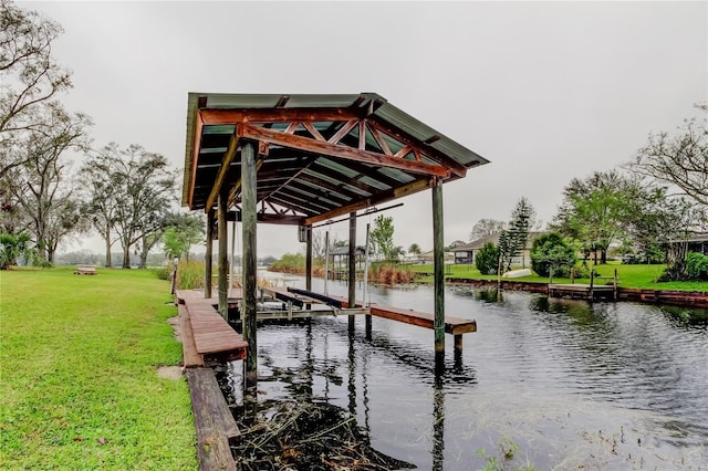 view of dock featuring a water view, boat lift, and a lawn