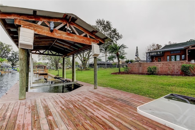 view of dock with a lawn, a water view, and fence