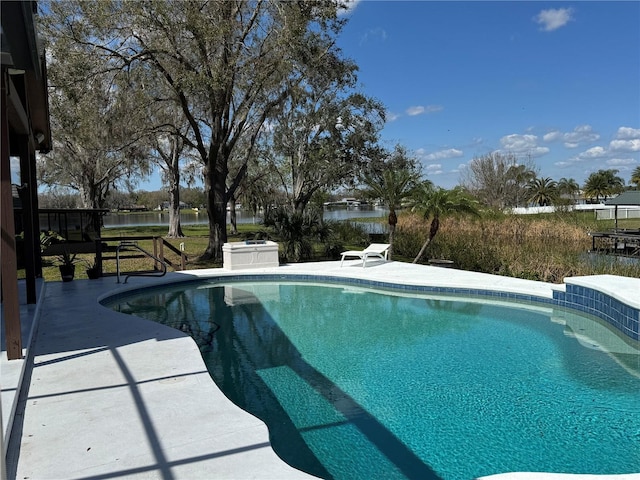 pool with a patio area and a water view