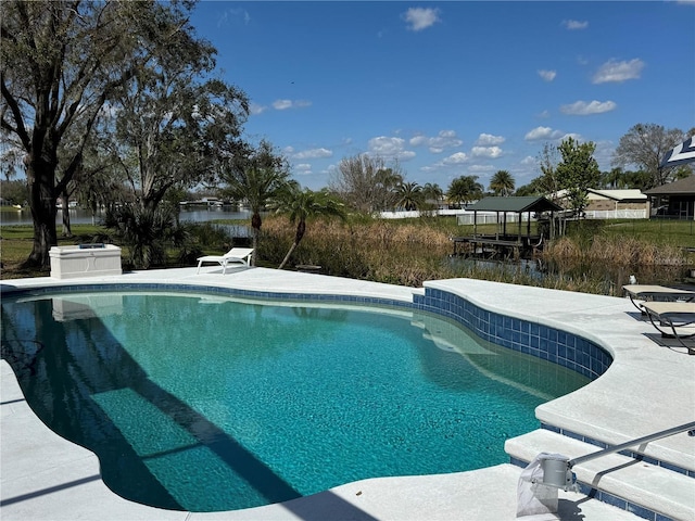 outdoor pool with a patio and a water view