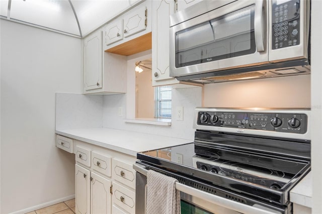 kitchen featuring ceiling fan, white cabinetry, stainless steel appliances, and light tile patterned floors