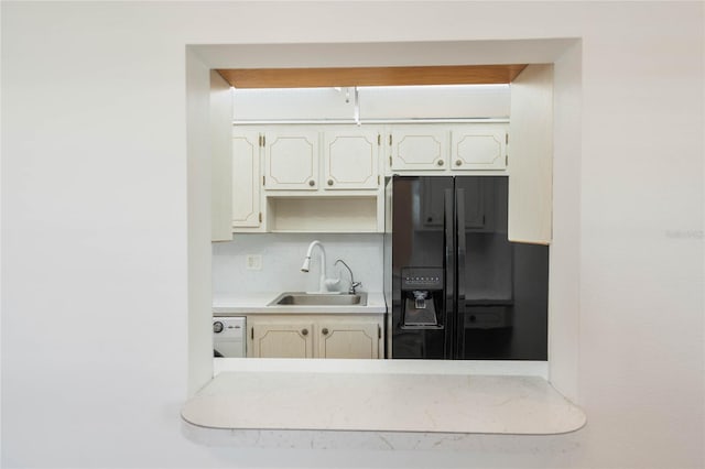 kitchen with black refrigerator with ice dispenser, sink, and white dishwasher