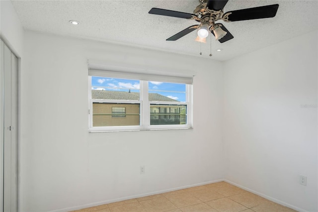 spare room with a textured ceiling and ceiling fan