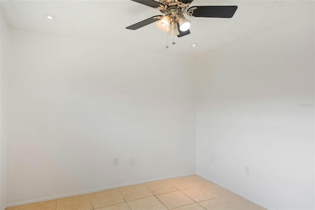 tiled spare room featuring ceiling fan