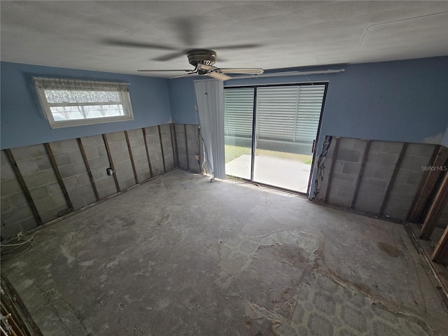 spare room with ceiling fan and concrete floors