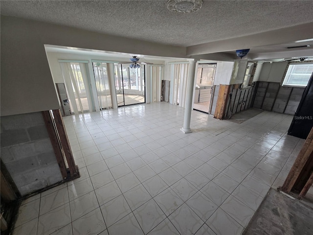 interior space with ceiling fan, light tile patterned floors, and a textured ceiling