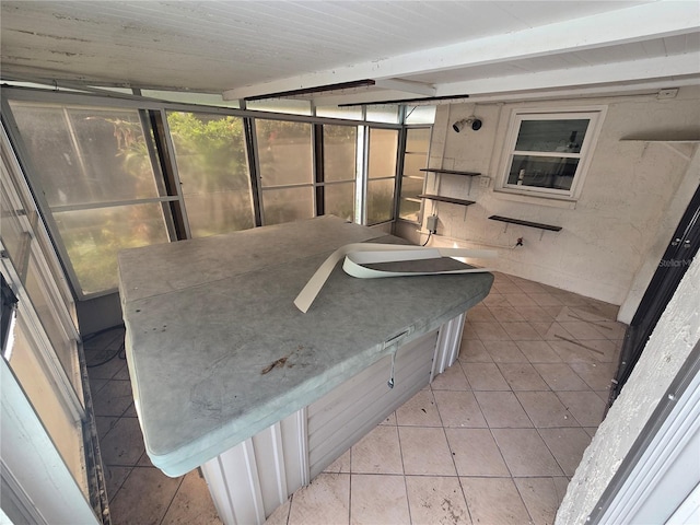 bathroom featuring beamed ceiling and tile patterned flooring