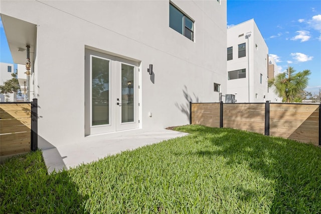 view of yard featuring fence and french doors