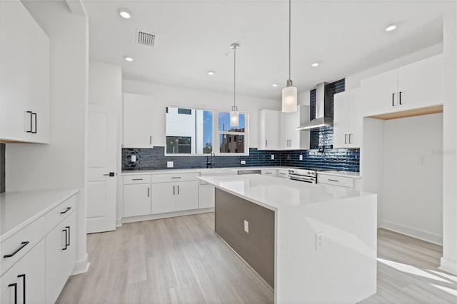 307 15th St N, Saint Petersburg, FL 33705 - kitchen with wall chimney exhaust hood, tasteful backsplash, visible vents, and light wood-style floors
