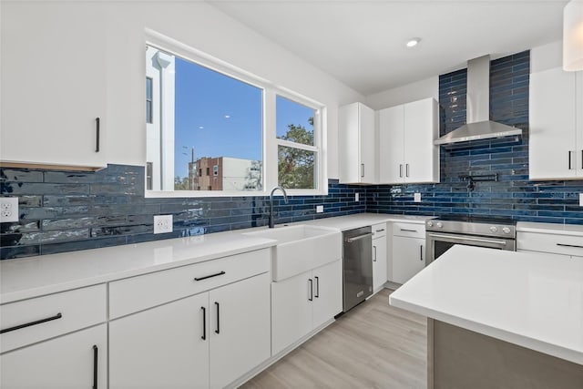 307 15th St N, Saint Petersburg, FL 33705 - kitchen with stainless steel appliances, wall chimney range hood, a sink, and decorative backsplash