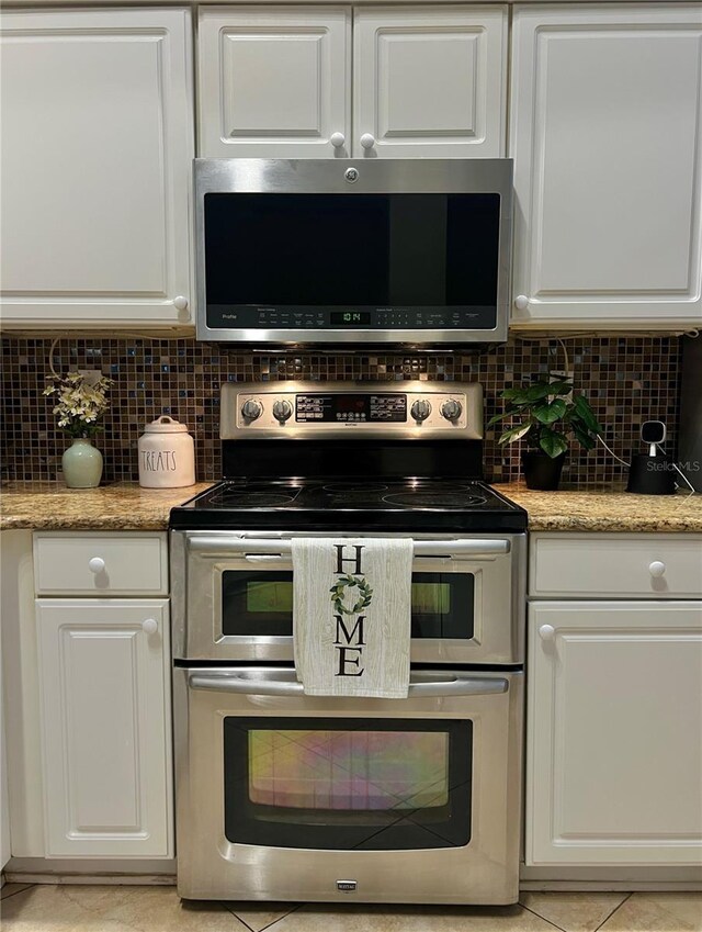 2015 Golf Manor Blvd, Valrico, FL 33596 - kitchen with light stone counters, decorative backsplash, white cabinets, and appliances with stainless steel finishes