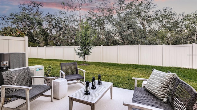 patio terrace at dusk featuring a lawn