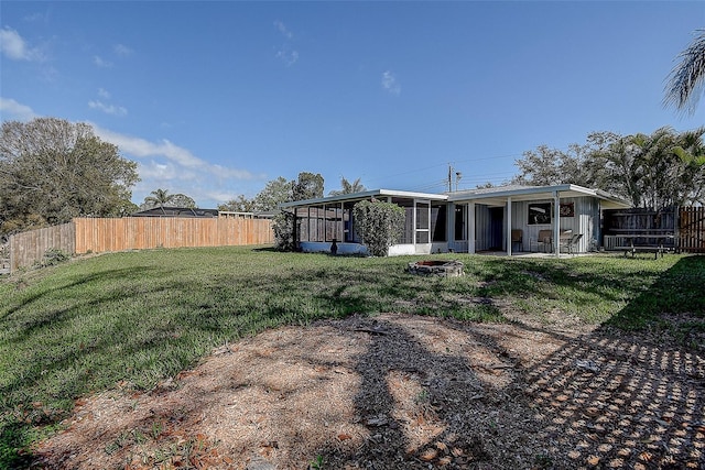 view of yard with a sunroom and a fenced backyard