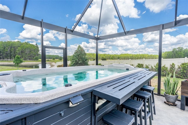 view of swimming pool with a water view and fence