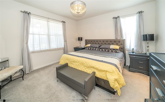 bedroom featuring light carpet, a notable chandelier, and baseboards