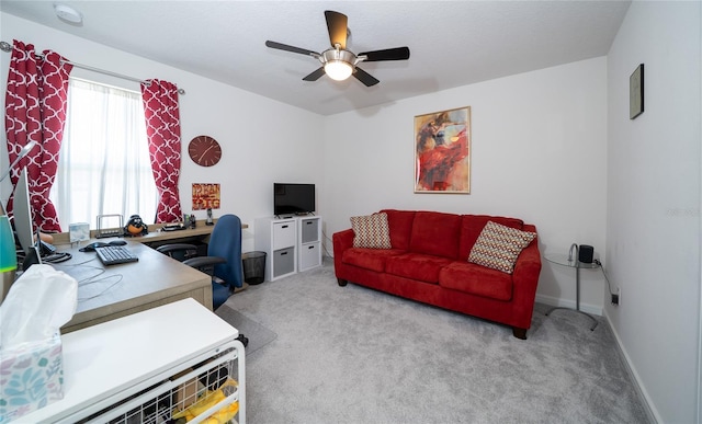 home office featuring light carpet, ceiling fan, and baseboards