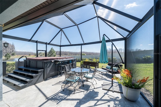 view of patio with a lanai, fence, and a hot tub