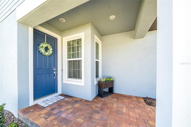 view of exterior entry with stucco siding