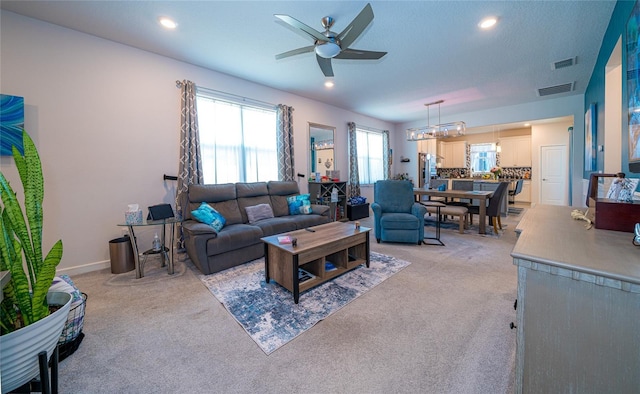 living room with ceiling fan, recessed lighting, visible vents, and light colored carpet