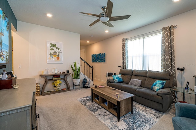 living area featuring recessed lighting, light colored carpet, ceiling fan, and stairway