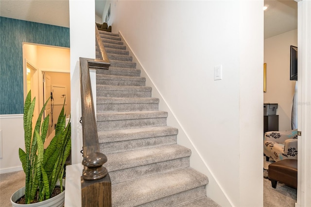 stairs with carpet flooring, baseboards, and wallpapered walls