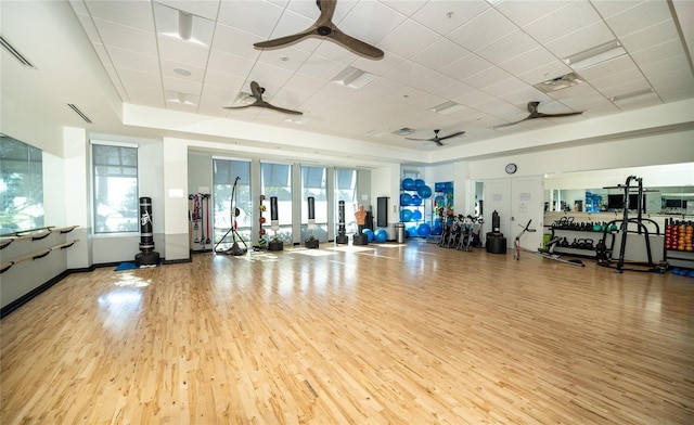 workout area featuring a paneled ceiling, visible vents, ceiling fan, and light wood finished floors