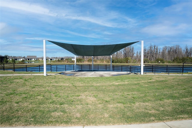 view of home's community featuring a yard, a water view, and fence