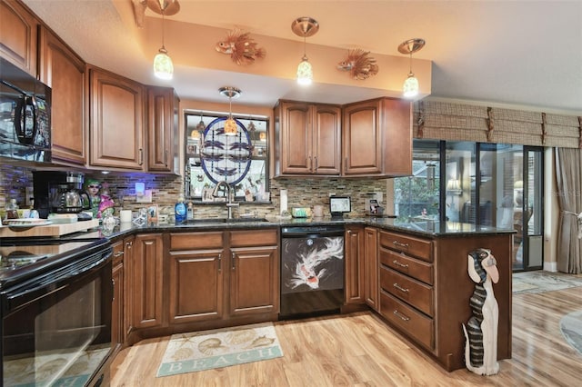 kitchen featuring black appliances, a sink, decorative light fixtures, and decorative backsplash