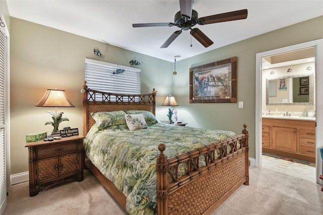 bedroom with a closet, ensuite bathroom, carpet flooring, ceiling fan, and baseboards