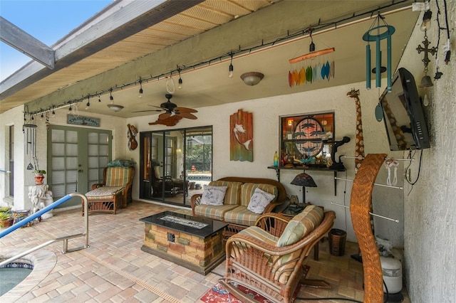 view of patio featuring an outdoor living space with a fire pit and a ceiling fan