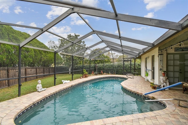 view of pool with glass enclosure, a patio area, a fenced backyard, and a fenced in pool