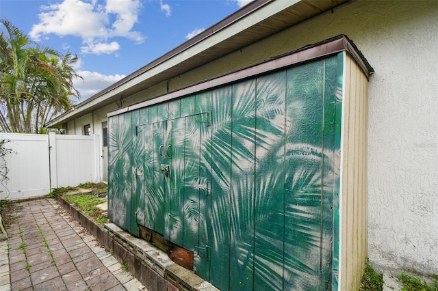 view of home's exterior with a patio area, fence, and stucco siding