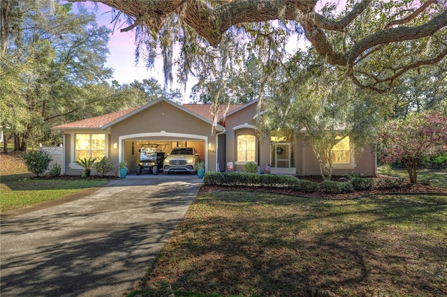 ranch-style home with a garage and a yard