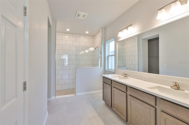 full bathroom with a walk in closet, double vanity, a sink, and a walk in shower