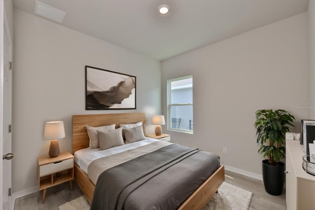 bedroom featuring baseboards, visible vents, and light wood-style flooring