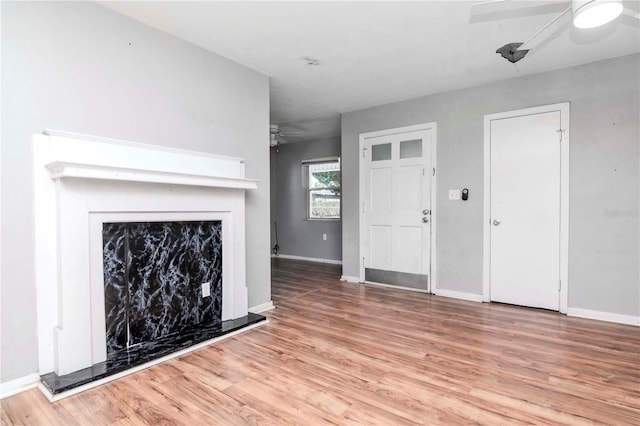 unfurnished living room featuring ceiling fan and light hardwood / wood-style flooring