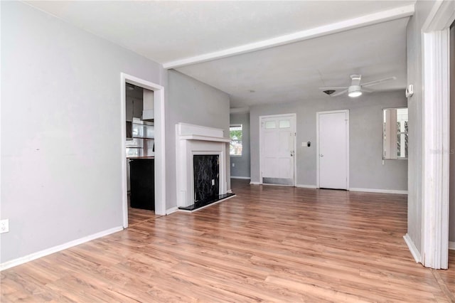 unfurnished living room with ceiling fan and light hardwood / wood-style flooring