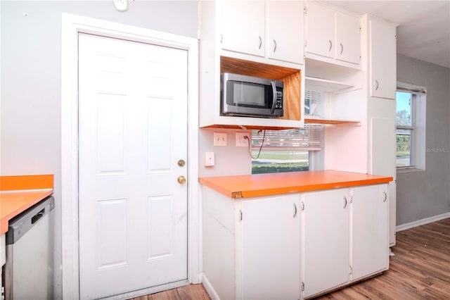 kitchen with appliances with stainless steel finishes, light wood-type flooring, and white cabinets