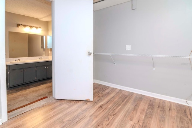 bathroom with hardwood / wood-style flooring, vanity, and a textured ceiling