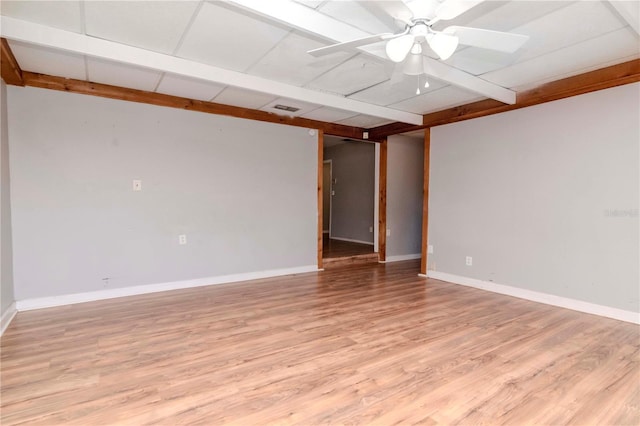 empty room featuring ceiling fan, beamed ceiling, and light hardwood / wood-style floors