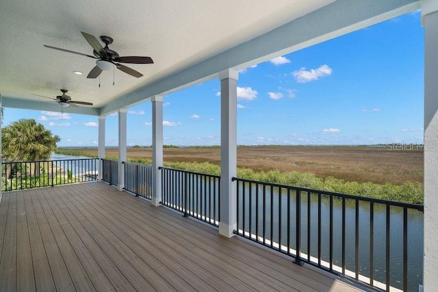 wooden deck featuring a water view and ceiling fan