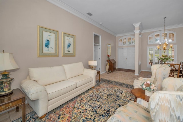 living room featuring visible vents, ornamental molding, an inviting chandelier, brick floor, and ornate columns