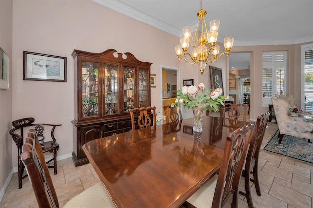 dining space with stone tile flooring, a notable chandelier, crown molding, and baseboards