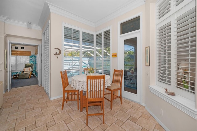 dining area with crown molding, stone finish floor, and baseboards